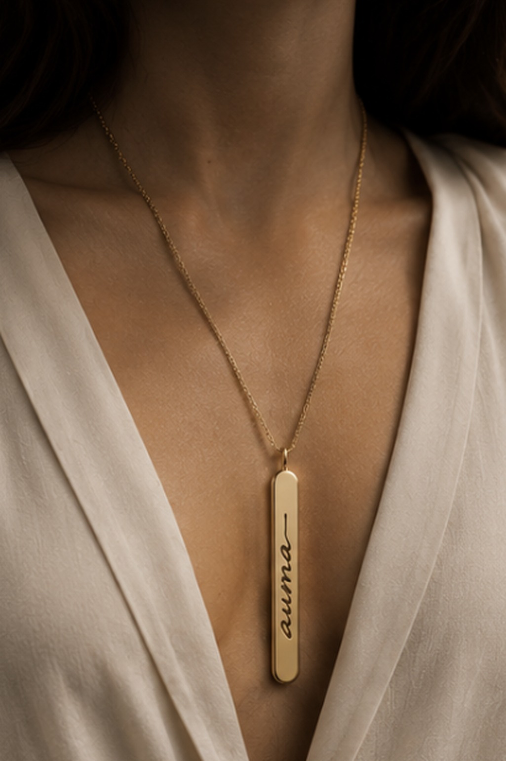 The gold Auma scent pendant worn on a fine chain